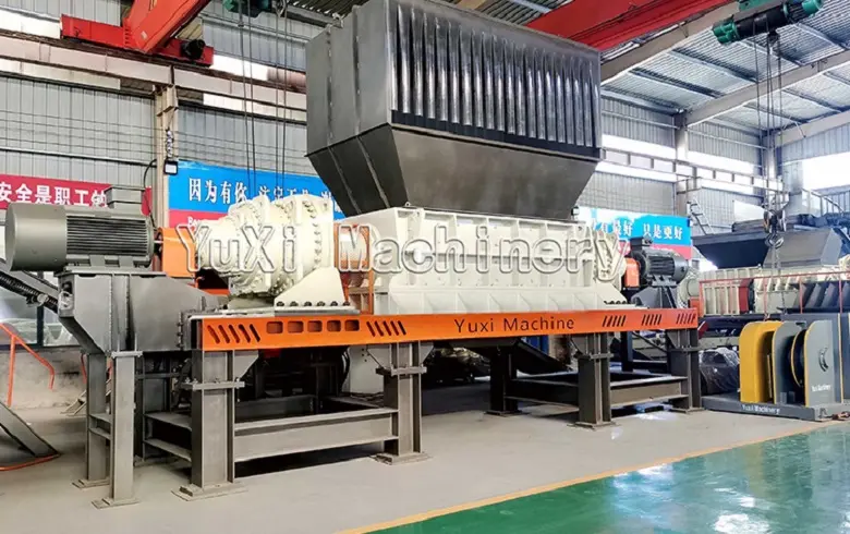 Twin shaft shredder integrated into a full production line setup inside the manufacturing facility.